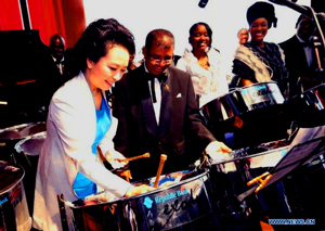 : Peng Liyuan, wife of Chinese President Xi Jinping, plays a steel drum after watching an artistic show by local performers at the national performing arts center in Port of Spain, Trinidad and Tobago, June 1, 2013.  