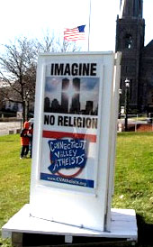 The 3-sided sign was erected in the Town of Vernon's Central Park on Dec. 1 by the Connecticut Valley Atheists. The two sides facing Main Street feature a pre-attack image of the Twin Towers with the sun shining between them and the message, "Imagine no religion," drawn from the John Lennon anthem, "Imagine."  